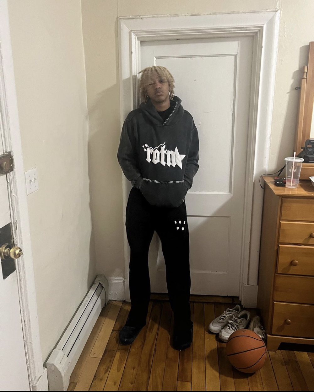 Rapper Rich Amiri wearing the ROTN sewn hoodie — the campaign shot for drop 001